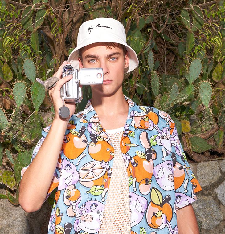 Man in fruit pattern shirt holding camera